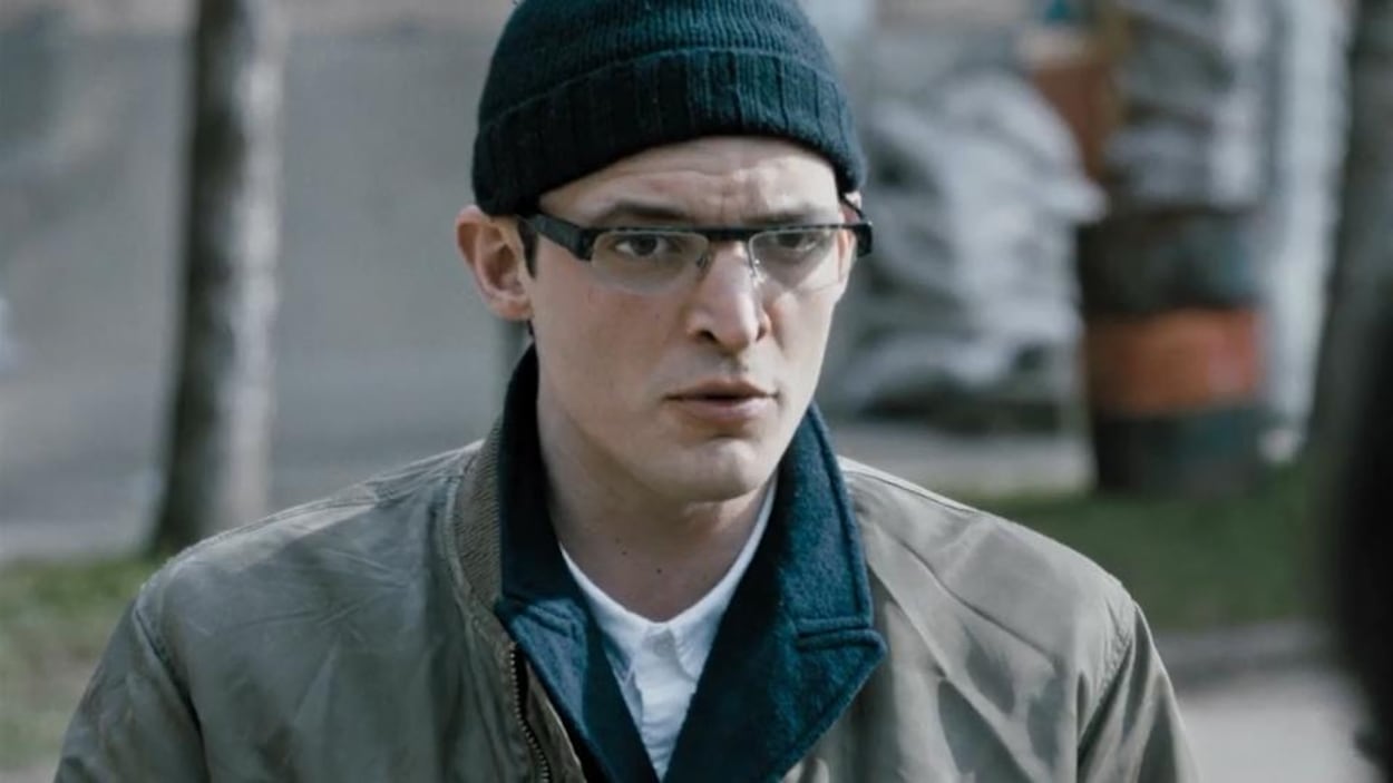 Un homme (Niels Schneider) portant un bonnet et des lunettes en plan moyen. Un homme (Niels Schneider) portant un bonnet et des lunettes en plan moyen.