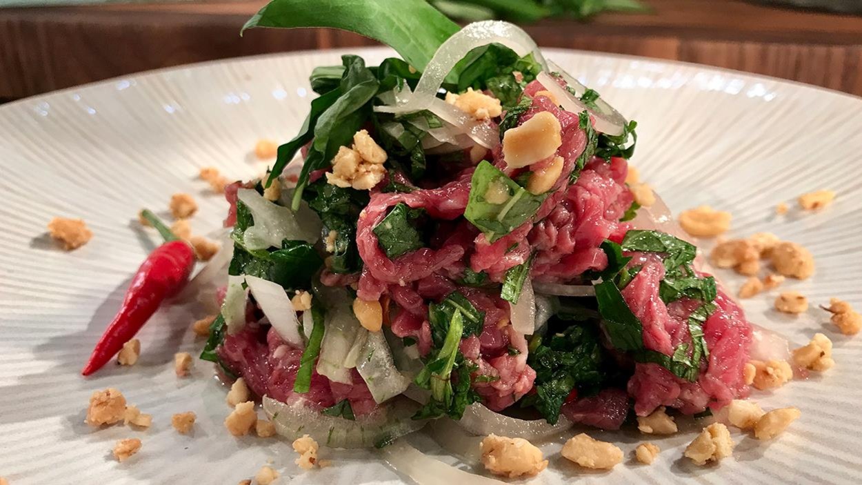 De la menthe, du basilic thaï, de la coriandre, des oignons et des arachides grillées font partie du tartare De la menthe, du basilic thaï, de la coriandre, des oignons et des arachides grillées font partie du tartare
