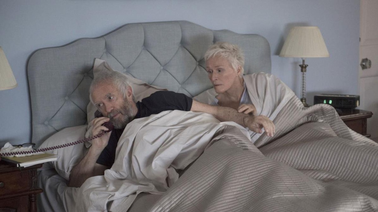 Dans un lit, un homme répond au téléphone, sa femme (Glenn Close) couchée à côté de lui, l'air intéressée. Dans un lit, un homme répond au téléphone, sa femme (Glenn Close) couchée à côté de lui, l'air intéressée.