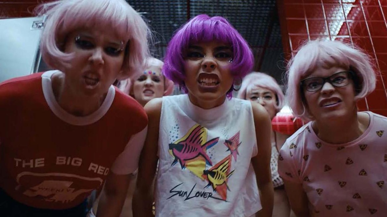 Des jeunes filles portant des perruques roses et violettes font des grimaces. Des jeunes filles portant des perruques roses et violettes font des grimaces.