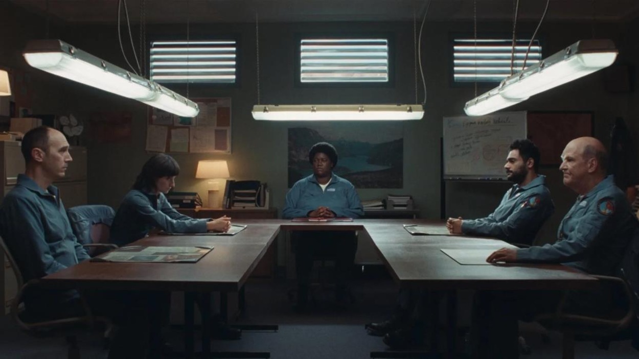 Cinq personnes, en uniformes, assises autour d'une table. Cinq personnes, en uniformes, assises autour d'une table.