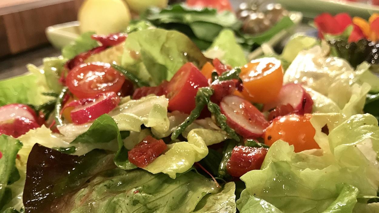 Une salade avec des tomates et de la vinaigrette