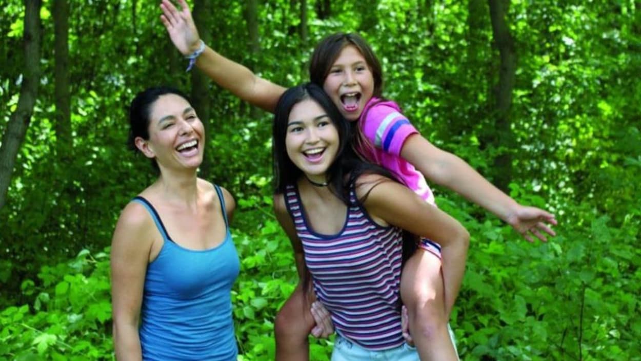 Une femme, une jeune fille et une petite fille sourient dans le bois. Une femme, une jeune fille et une petite fille sourient dans le bois.