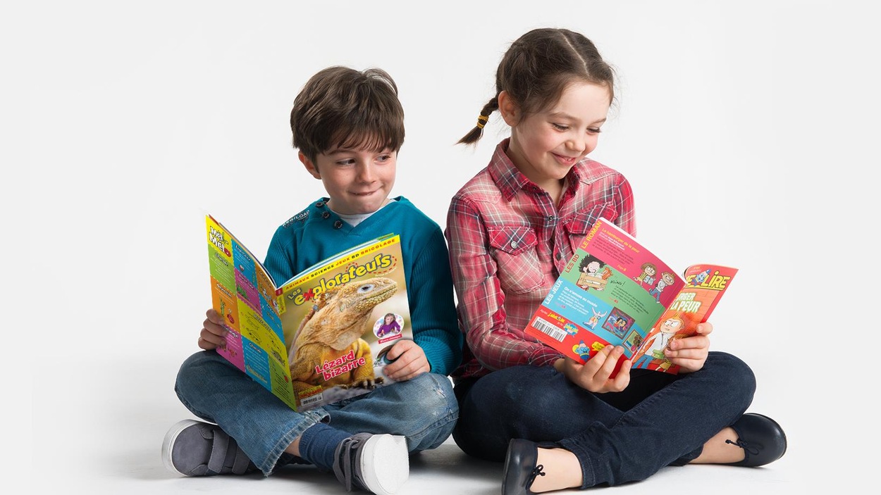 Une fille et un garçon lisent chacun un magazine. Une fille et un garçon lisent chacun un magazine.
