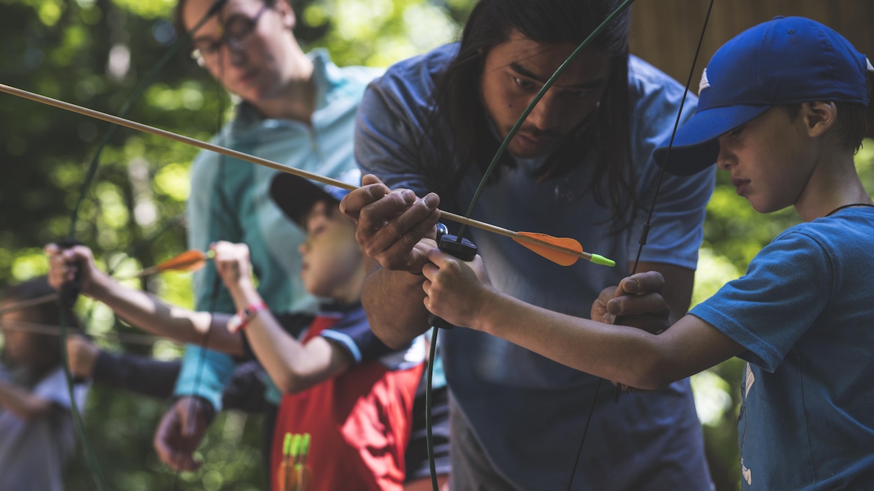 Des animateurs donnent une activité de tir à l'arc aux enfants Des animateurs donnent une activité de tir à l'arc aux enfants