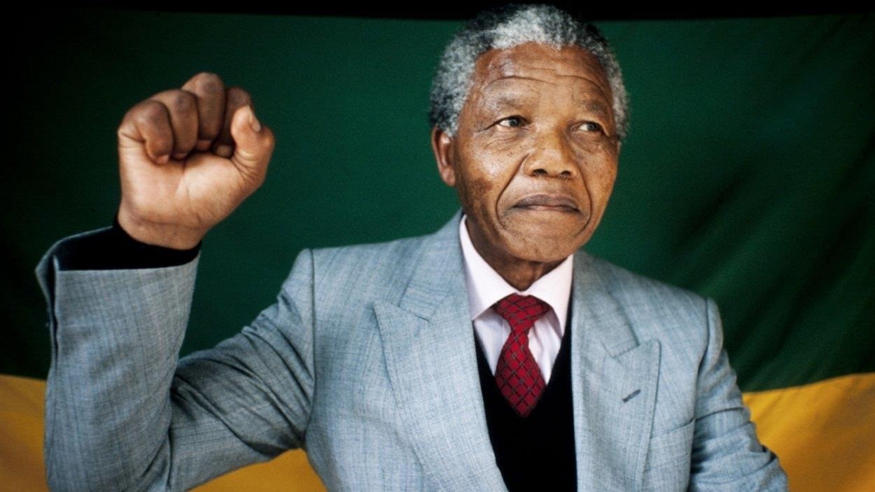 Nelson Mandela lève le poing droit.