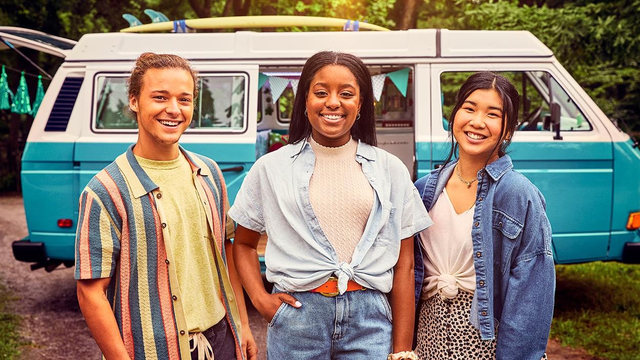 Les trois ados sourient en posant devant leur van