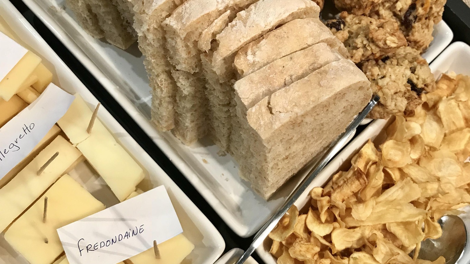 Un plateau contenant des fromages, du pain, des biscuits, des croustilles et du beurre Un plateau contenant des fromages, du pain, des biscuits, des croustilles et du beurre