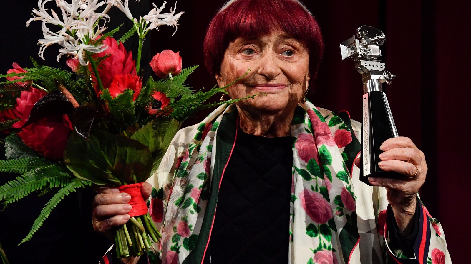 La femme tient un bouquet de fleurs et un trophée. La femme tient un bouquet de fleurs et un trophée.