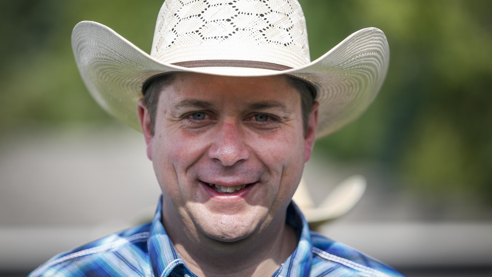 Andrew Scheer porte un chapeau de cowboy et sourit fièrement. Andrew Scheer porte un chapeau de cowboy et sourit fièrement.