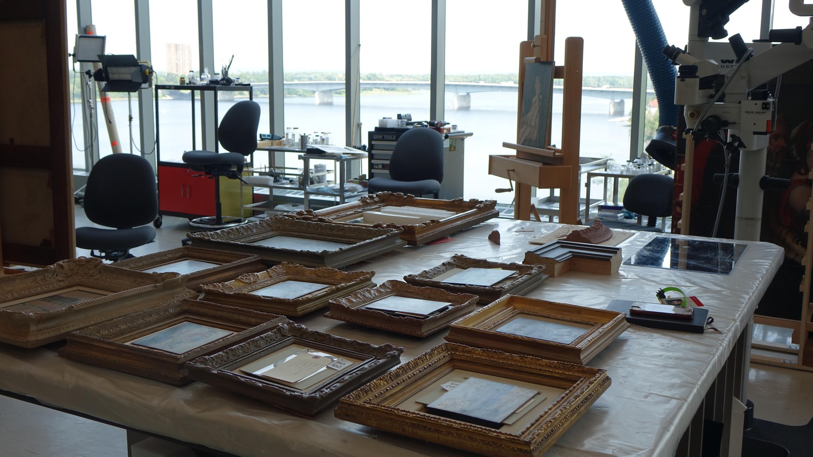La photo montre un atelier très éclairé dans lequel se retrouvent plusieurs oeuvres d'art encadrées. La photo montre un atelier très éclairé dans lequel se retrouvent plusieurs oeuvres d'art encadrées.