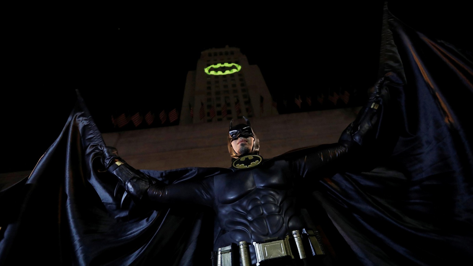 Une personne déguisée en Batman prend la pose devant une projection sur l'hôtel de ville de Los Angeles, en Californie, en hommage à l'acteur Adam West qui incarnait le personnage. Une personne déguisée en Batman prend la pose devant une projection sur l'hôtel de ville de Los Angeles, en Californie, en hommage à l'acteur Adam West qui incarnait le personnage.