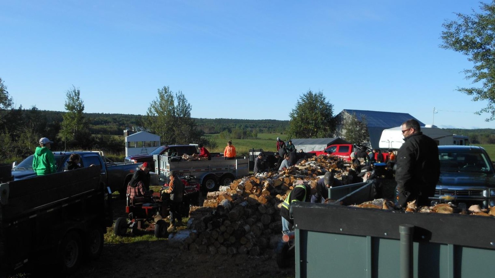 Des bénévoles s'affairent à remplir des remorques de bois de chauffage. Des bénévoles s'affairent à remplir des remorques de bois de chauffage.