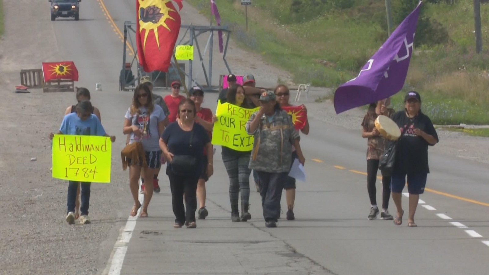 Des manifestants autochtones avancent sur une route. Des manifestants autochtones avancent sur une route.