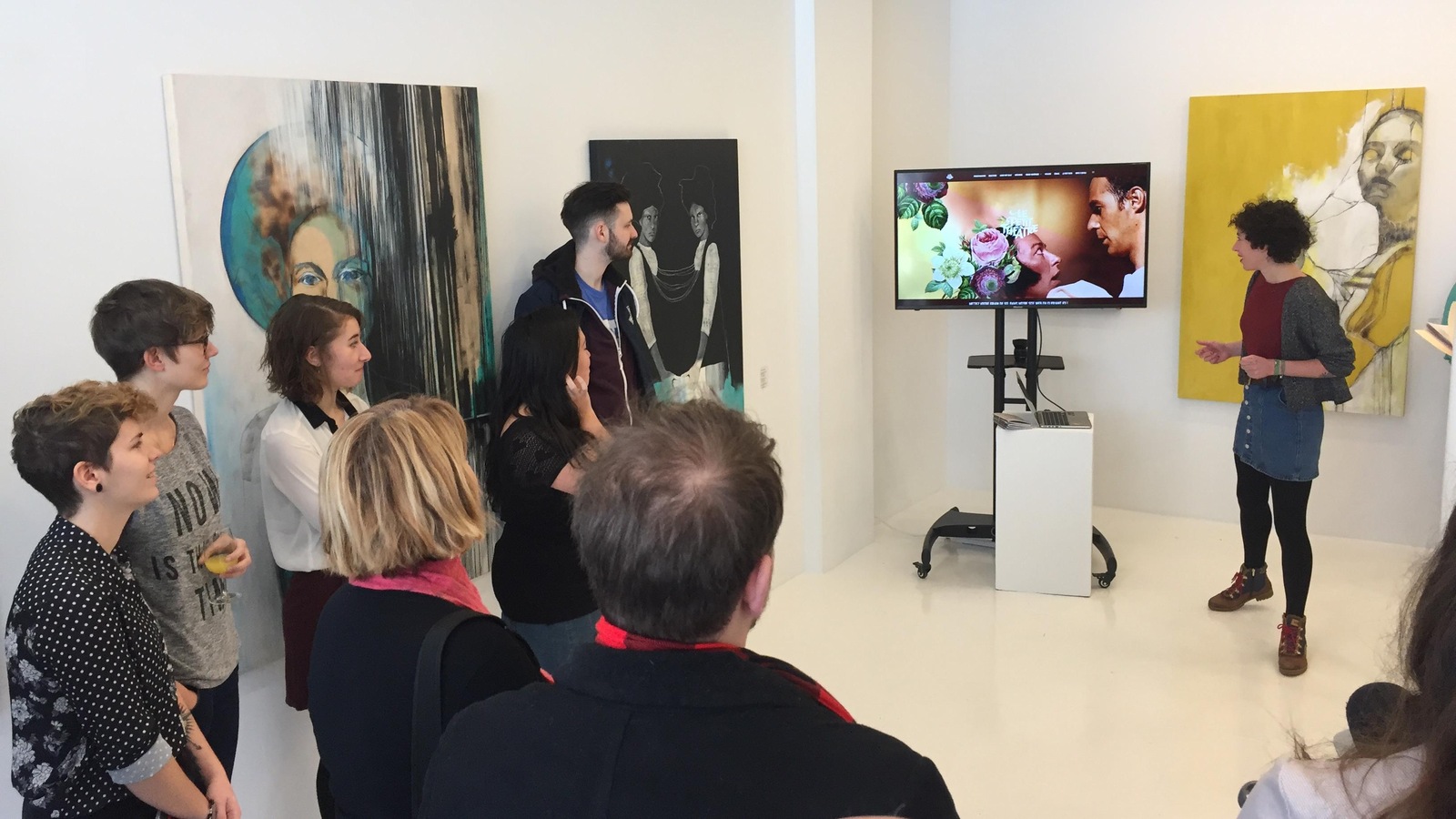 La gestionnaire web du Petit théâtre du Vieux Noranda, Camille Barbotteau, parle devant près d'une dizaine de personnes et pointe un écran de télévision. La gestionnaire web du Petit théâtre du Vieux Noranda, Camille Barbotteau, parle devant près d'une dizaine de personnes et pointe un écran de télévision.