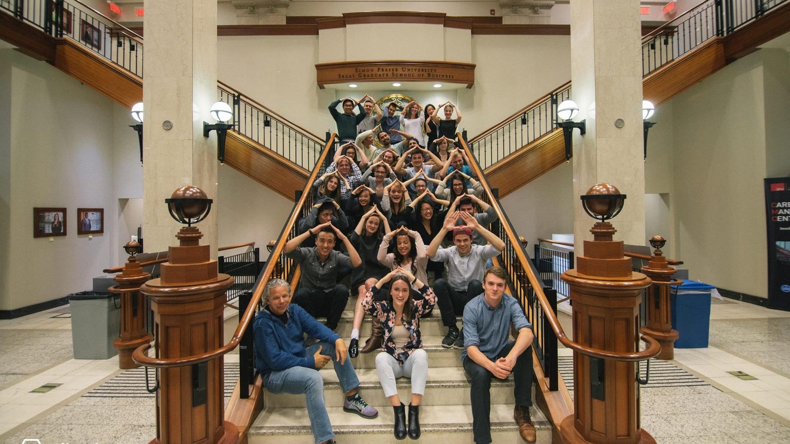Les membres de City Hive posent dans un escalier avec les mains en triangle au-dessus de leur tête. Les membres de City Hive posent dans un escalier avec les mains en triangle au-dessus de leur tête.