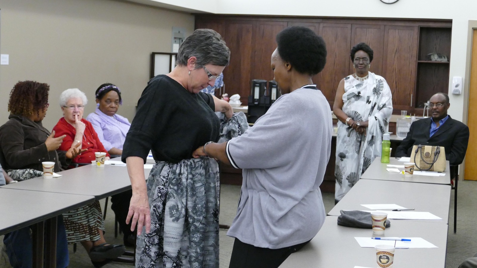 Une femme blanche se fait habiller dans un pagne africain par une femme noire. Une femme blanche se fait habiller dans un pagne africain par une femme noire.