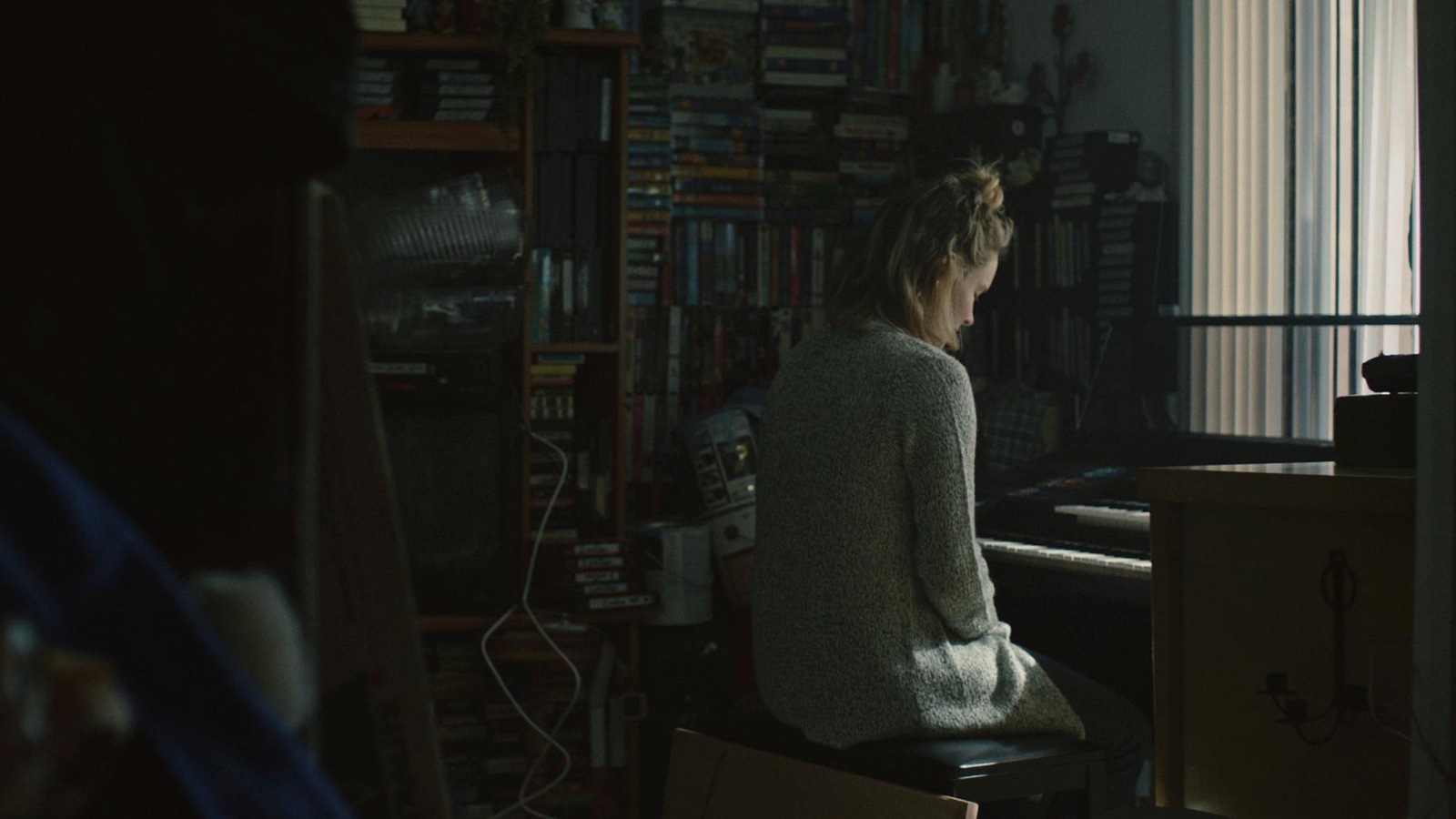 Une femme devant une mur de disques. Elle est assise devant un clavier pour jouer de la musique. Une femme devant une mur de disques. Elle est assise devant un clavier pour jouer de la musique.