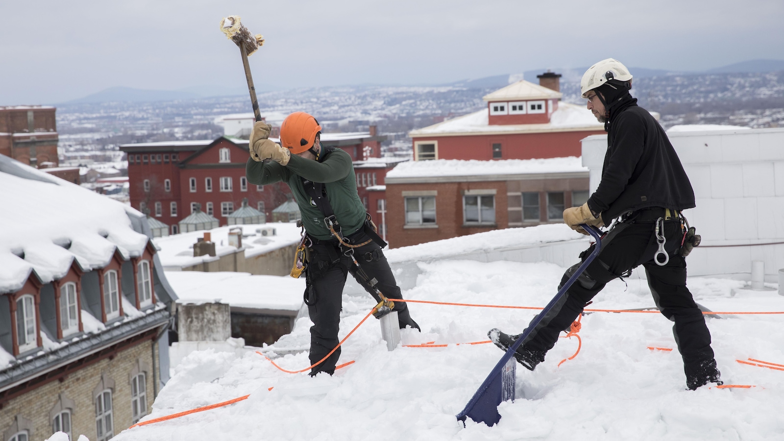 Des travailleurs sur un toit dans le Vieux-Québec Des travailleurs sur un toit dans le Vieux-Québec