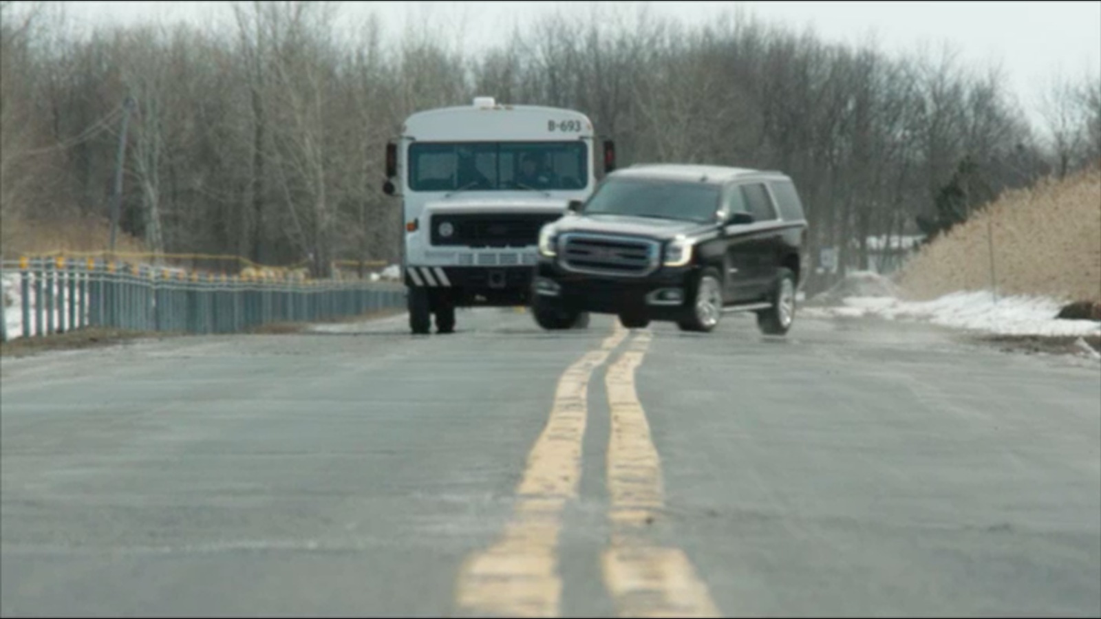 Une grosse voiture noire passe devant un mini bus. Une grosse voiture noire passe devant un mini bus.