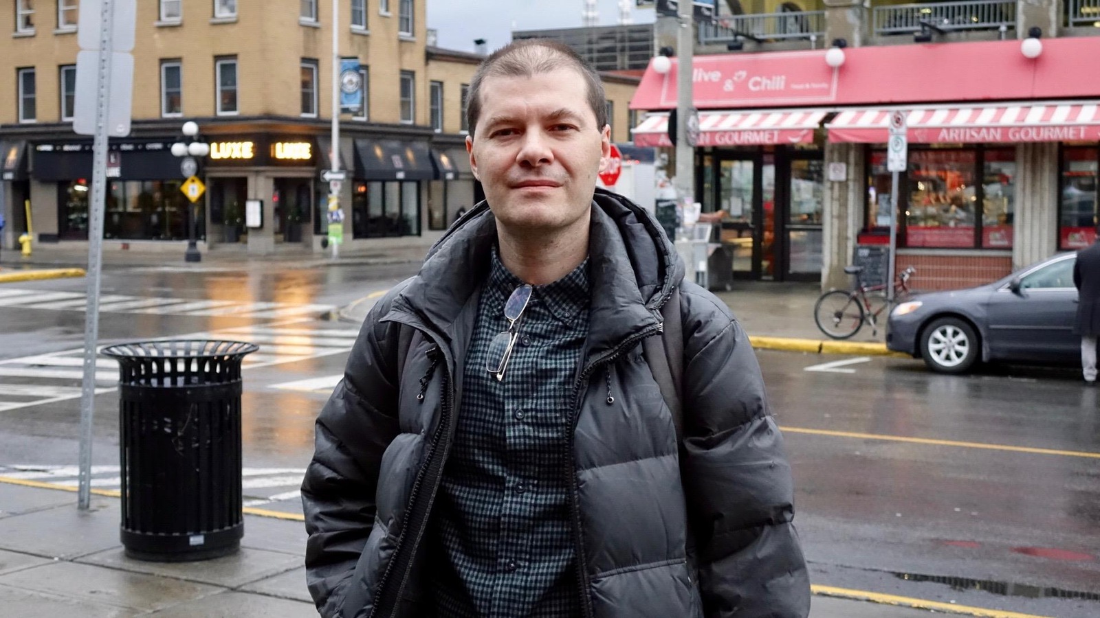 Un homme photographié dans une rue passante par une journée pluvieuse Un homme photographié dans une rue passante par une journée pluvieuse