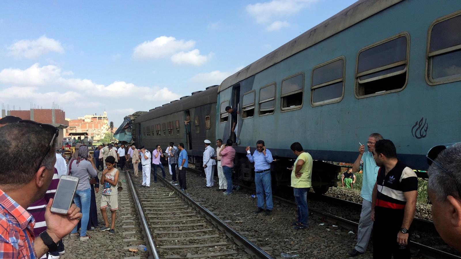 Des Égyptiens constatent l'état de la situation après la collision ferroviaire. Des Égyptiens constatent l'état de la situation après la collision ferroviaire.
