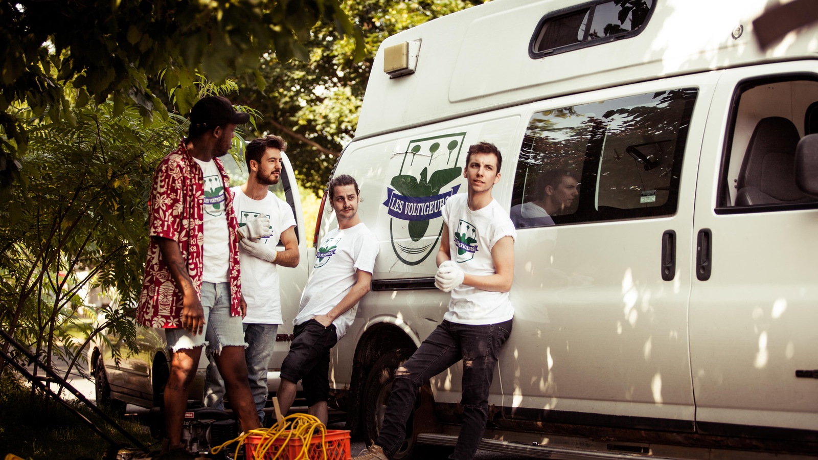 Quatre jeunes hommes sont à côté d'un camion. Quatre jeunes hommes sont à côté d'un camion.