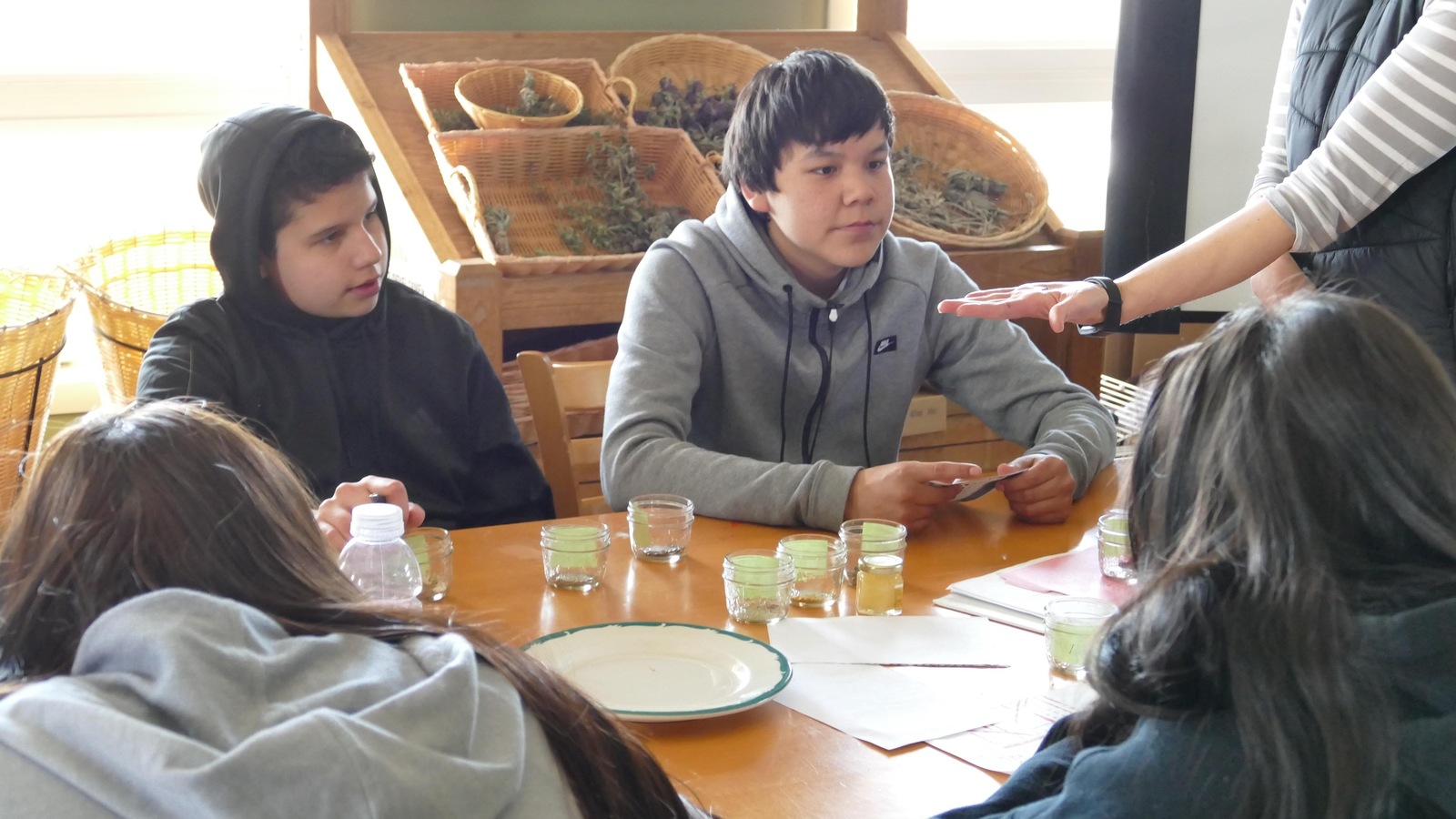 Deux adolescents regardent des graines dans la main d'un éducateur. Deux adolescents regardent des graines dans la main d'un éducateur.