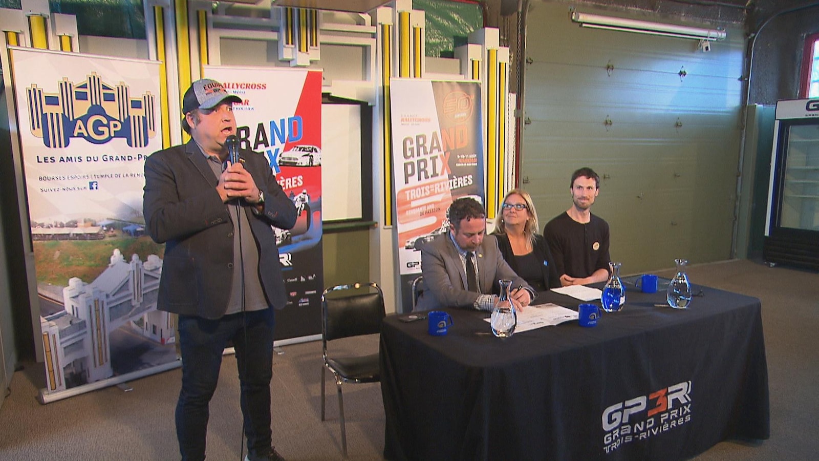 Dominique Fugère, le DG du Grand prix de Trois-Rivières, au micro et des gens assis à une table Dominique Fugère, le DG du Grand prix de Trois-Rivières, au micro et des gens assis à une table