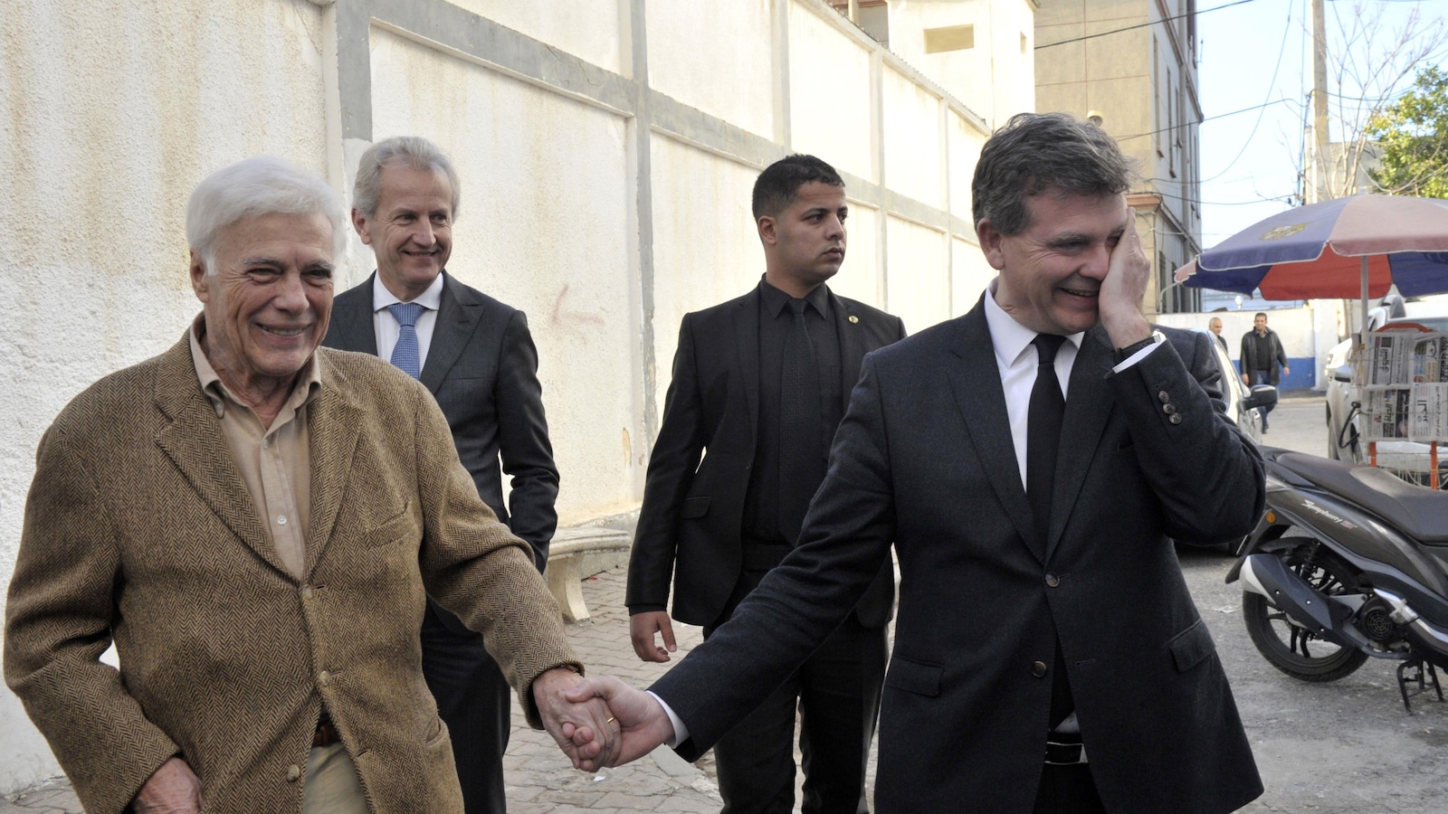 L'humoriste français Guy Bedos et l'homme politique Arnaud Montebourg se tiennent la main dans la rue lors de la campagne des primaires de la gauche en France, en décembre 2016. L'humoriste français Guy Bedos et l'homme politique Arnaud Montebourg se tiennent la main dans la rue lors de la campagne des primaires de la gauche en France, en décembre 2016.