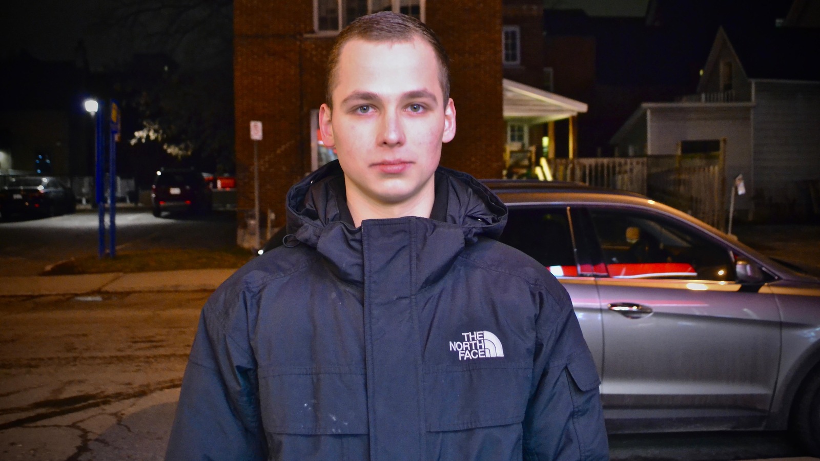 Un jeune homme photographié dans une rue la nuit Un jeune homme photographié dans une rue la nuit