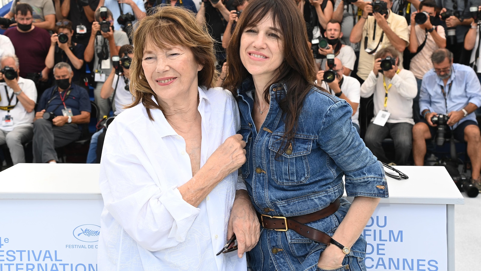 Deux femmes sourient et se font prendre en photo. En arrière-plan, plusieurs photographes ont des appareils photos dans les mains. Deux femmes sourient et se font prendre en photo. En arrière-plan, plusieurs photographes ont des appareils photos dans les mains.