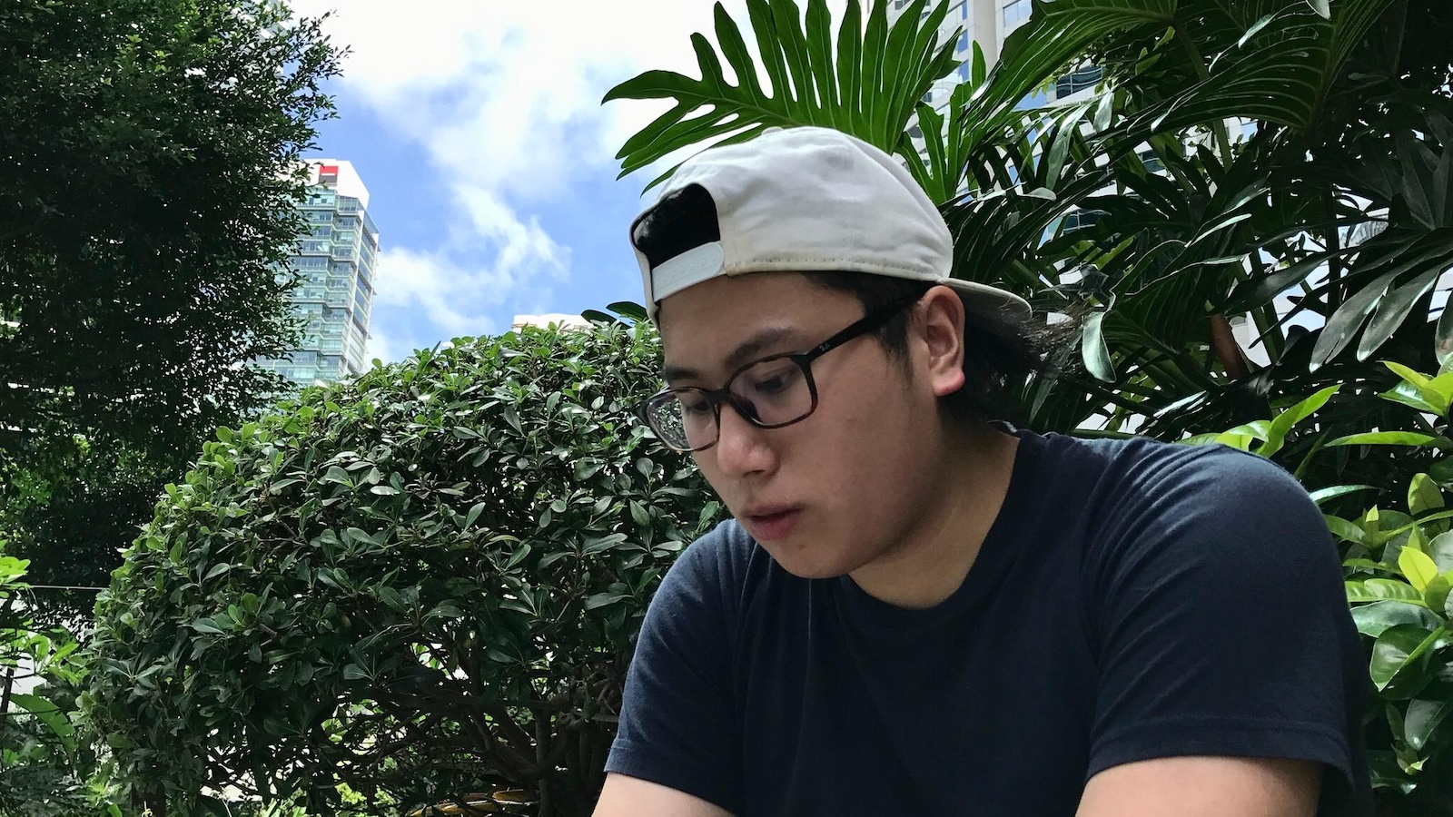 Franco porte une casquette blanche, un t-shirt noir et des lunettes Franco porte une casquette blanche, un t-shirt noir et des lunettes