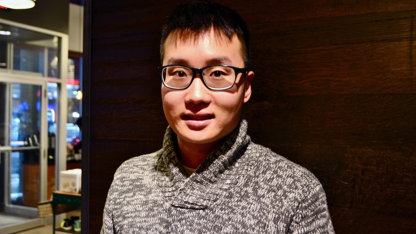 Un jeune homme portant des lunettes photographié dans un café Un jeune homme portant des lunettes photographié dans un café