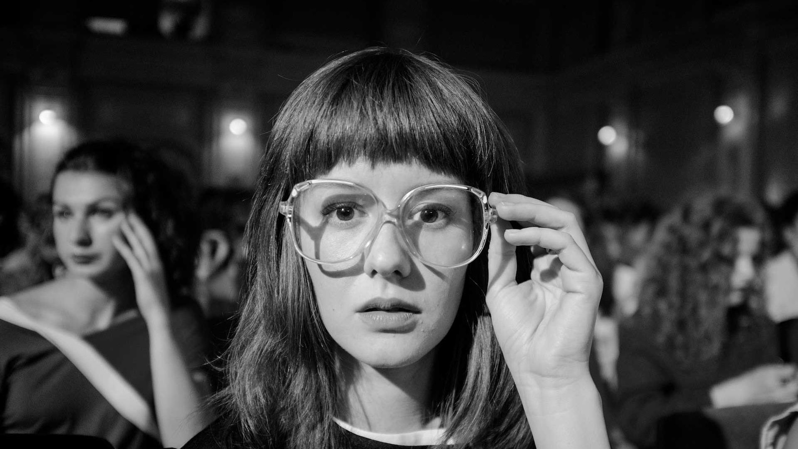 Image en noir et blanc montrant le visage d'une jeune femme portant de grandes lunettes de vision. Image en noir et blanc montrant le visage d'une jeune femme portant de grandes lunettes de vision.