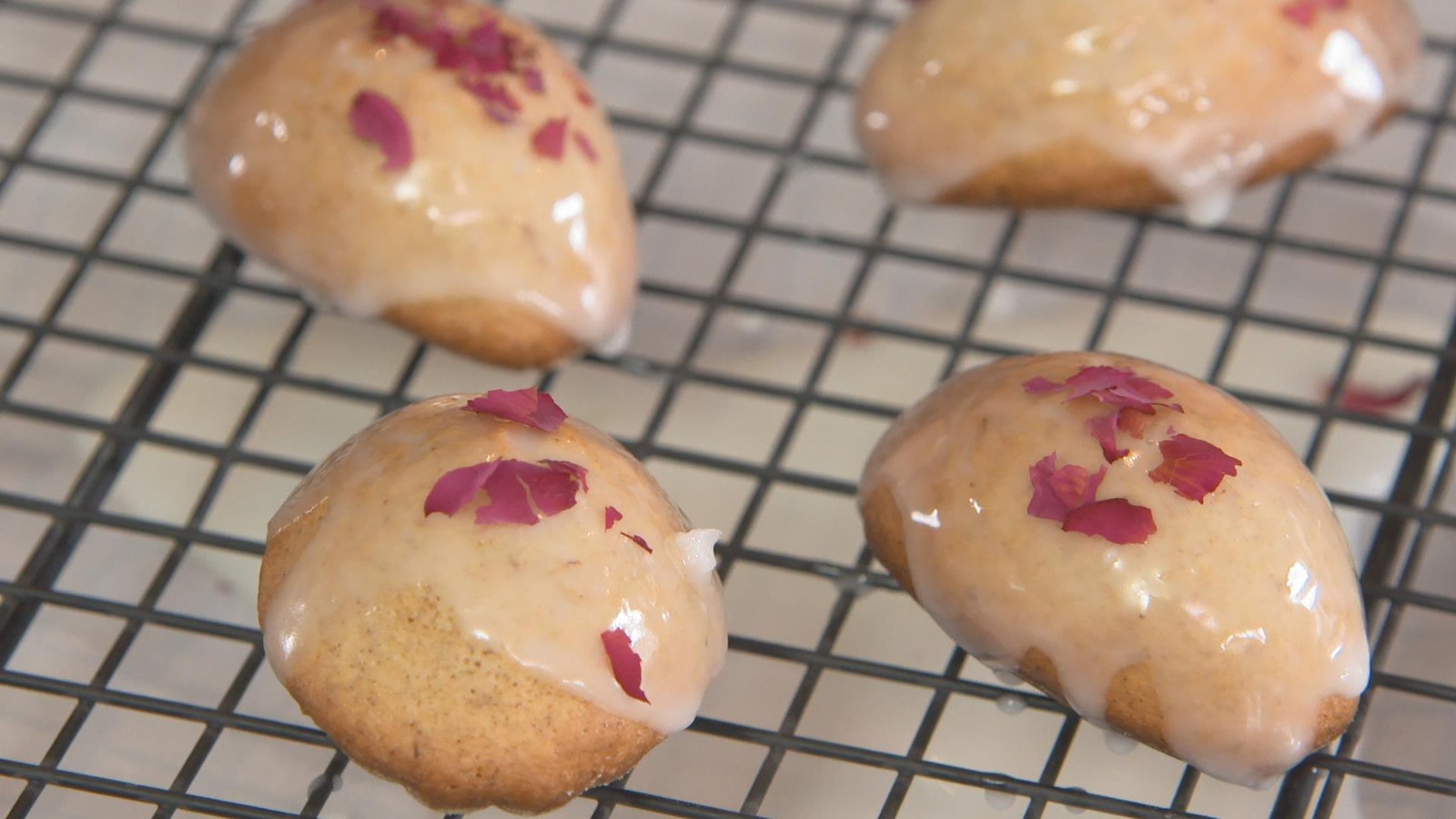Quatre madeleines glacées avec des feuilles de rooibos sur une grille. Quatre madeleines glacées avec des feuilles de rooibos sur une grille.