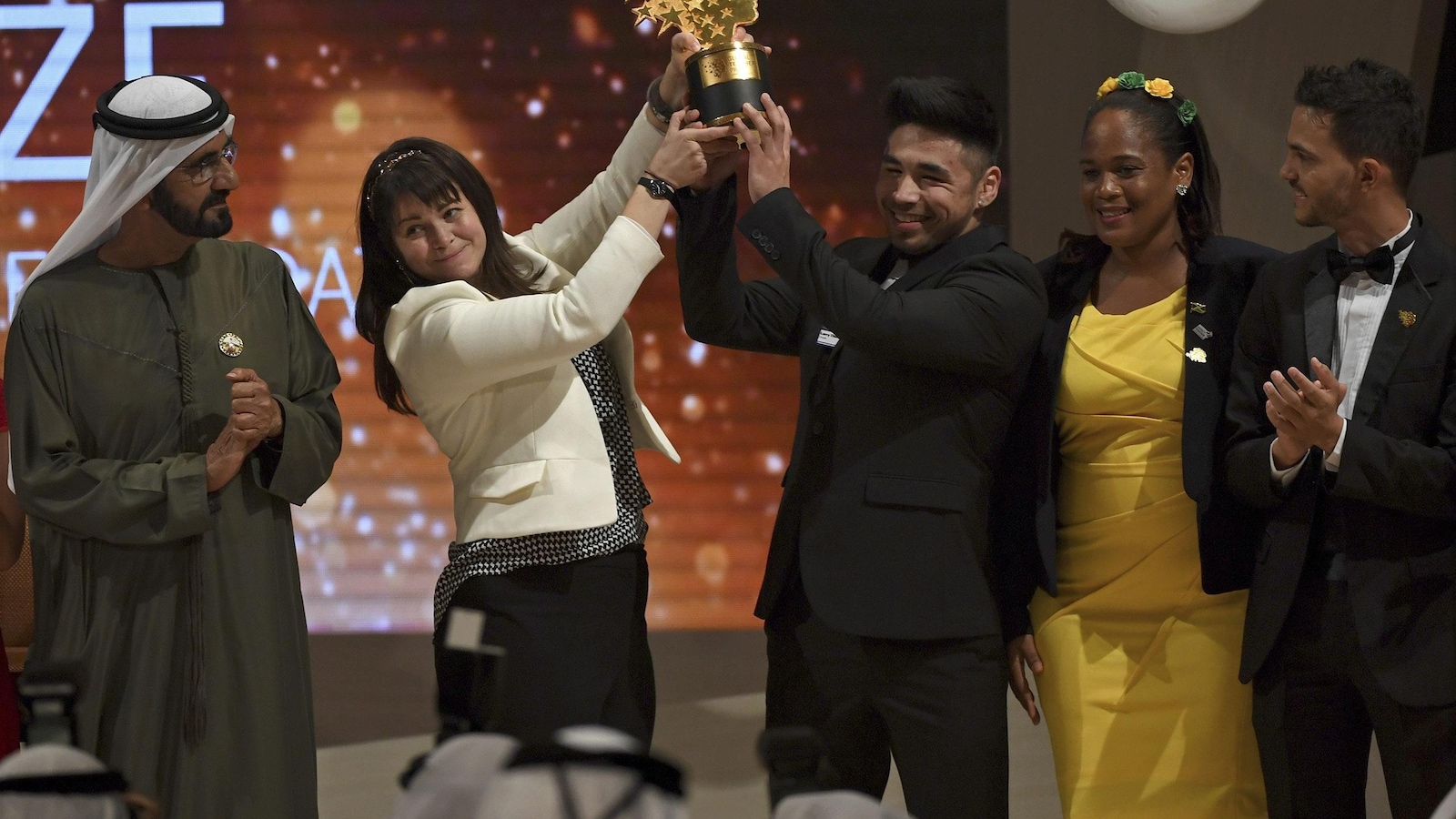 Maggie MacDonnelle accepte le Global Teacher Prize en compagnie de ses étudiants Maggie MacDonnelle accepte le Global Teacher Prize en compagnie de ses étudiants
