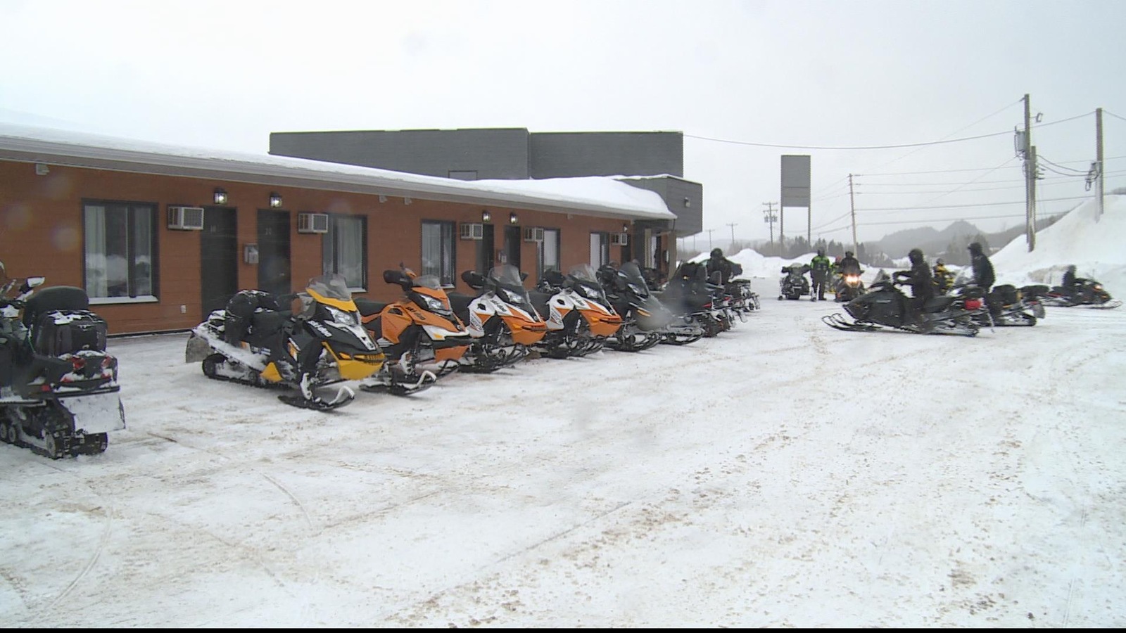 Des motoneigistes devant une partie du Motel Interprovincial à Pointe-à-la-Croix. Des motoneigistes devant une partie du Motel Interprovincial à Pointe-à-la-Croix.