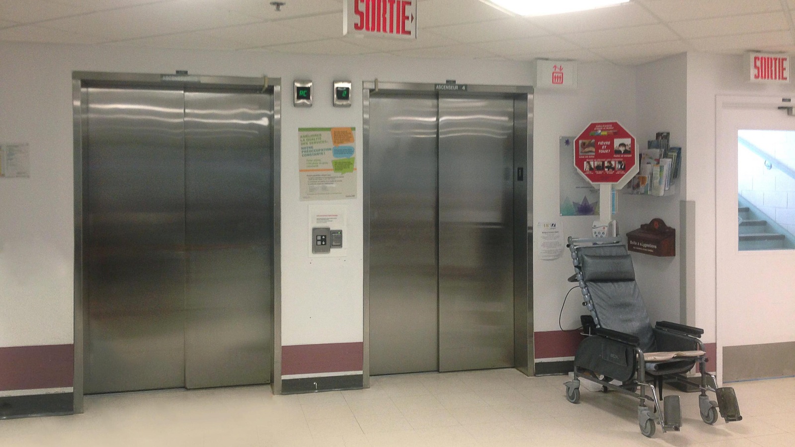 Des portes d'ascenseurs d'un CHSLD. Un fauteuil roulant se trouve à proximité. Des portes d'ascenseurs d'un CHSLD. Un fauteuil roulant se trouve à proximité.