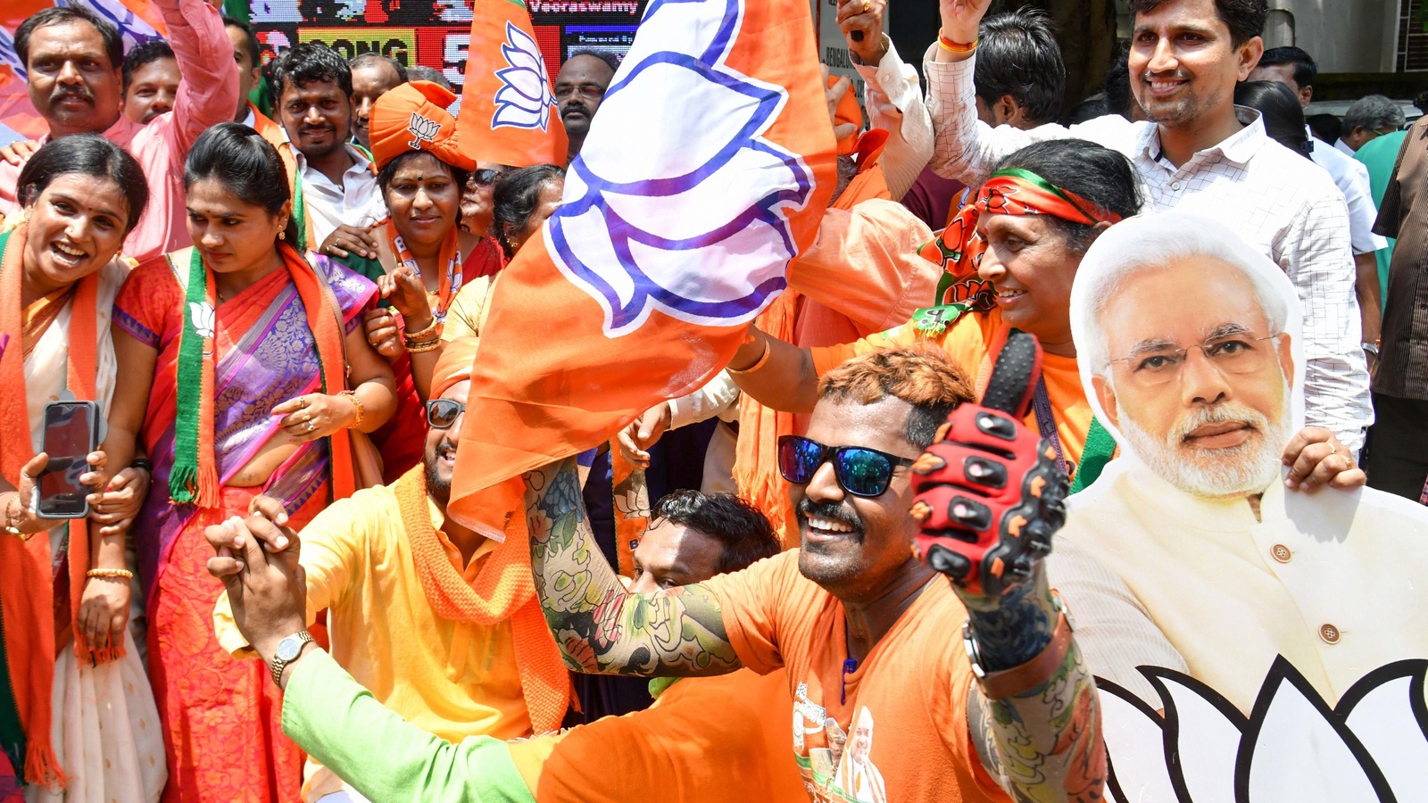 Des gens habillés de vêtements saffran (couleur du BJP) agitent des drapeaux de leur parti. Des gens habillés de vêtements saffran (couleur du BJP) agitent des drapeaux de leur parti.