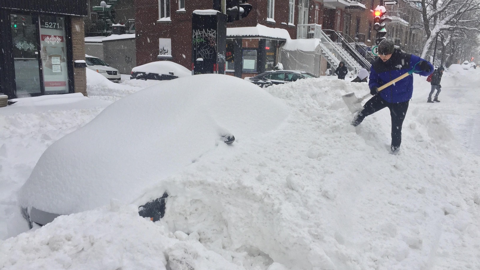 Un homme déneige sa voiture. Un homme déneige sa voiture.