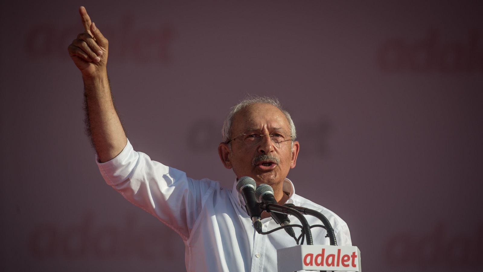 Kemal Kilicdaroglu livre un discours au micro, la main droit levée dans les airs. Kemal Kilicdaroglu livre un discours au micro, la main droit levée dans les airs.