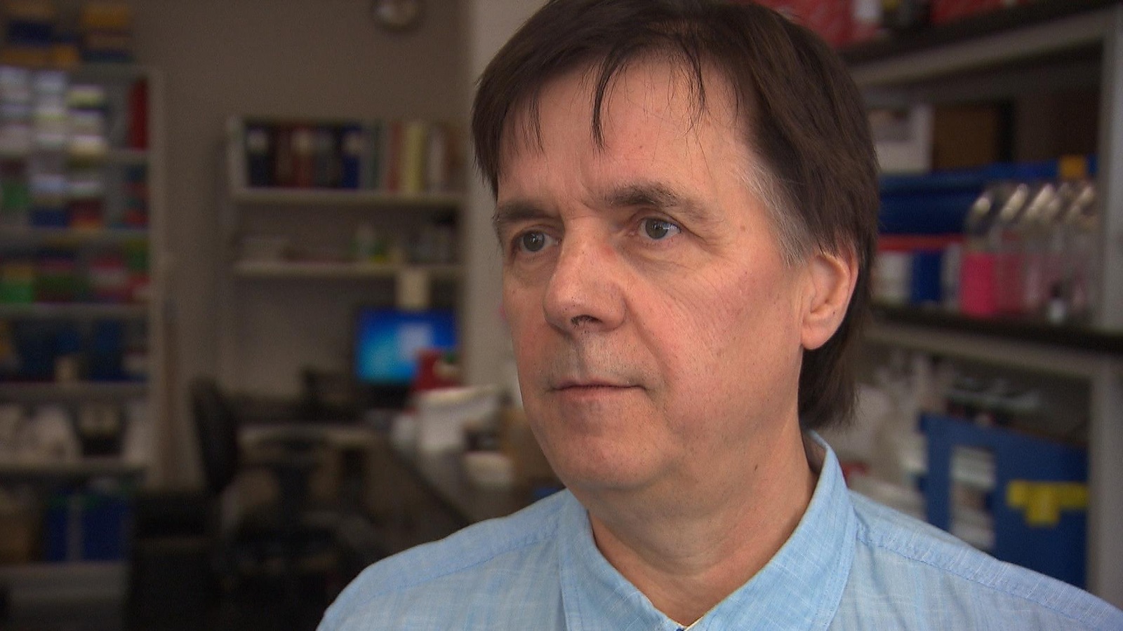 Un homme dans un laboratoire de recherche regarde un journaliste lors d'une entrevue. Un homme dans un laboratoire de recherche regarde un journaliste lors d'une entrevue.