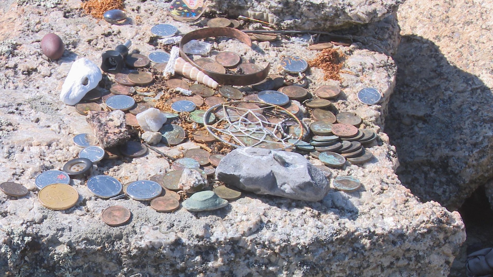 Des pièces de monnaie, des bijoux, un capteur de rêves et d'autres petits objets. Des pièces de monnaie, des bijoux, un capteur de rêves et d'autres petits objets.