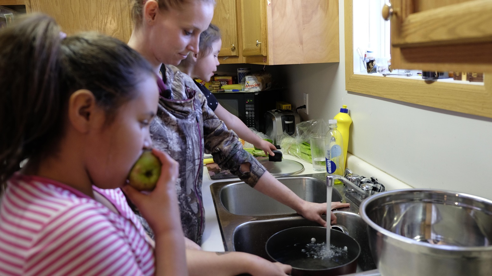 Jessy Sabourin, au centre, remplit un chaudron avec de l'eau du robinet pour faire cuire des pâtes. Ses filles Natalie, 9 ans et Abby, 4 ans, l'observe. Jessy Sabourin, au centre, remplit un chaudron avec de l'eau du robinet pour faire cuire des pâtes. Ses filles Natalie, 9 ans et Abby, 4 ans, l'observe.