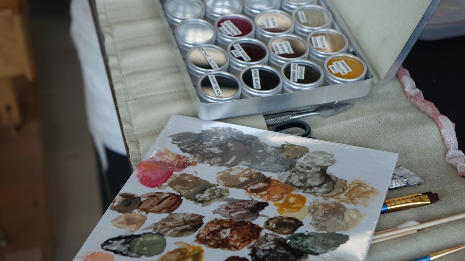La photo montre une palette de peinture et des pigments de couleurs. La photo montre une palette de peinture et des pigments de couleurs.