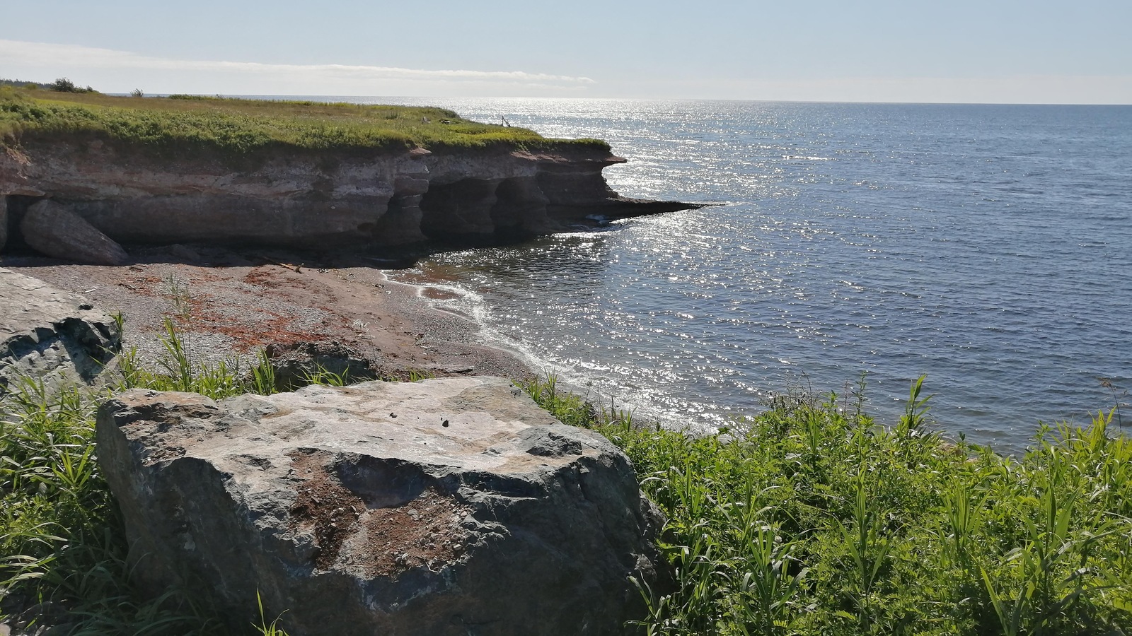 Une petite plage est encastrée entre deux escarpements, et s'ouvre sur le fleuve. Une petite plage est encastrée entre deux escarpements, et s'ouvre sur le fleuve.