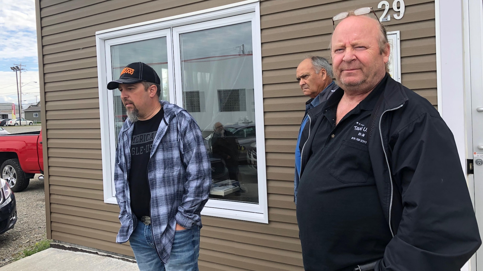 Trois hommes font le pied de grue devant le bureau de la députée Suzanne Blais. Trois hommes font le pied de grue devant le bureau de la députée Suzanne Blais.