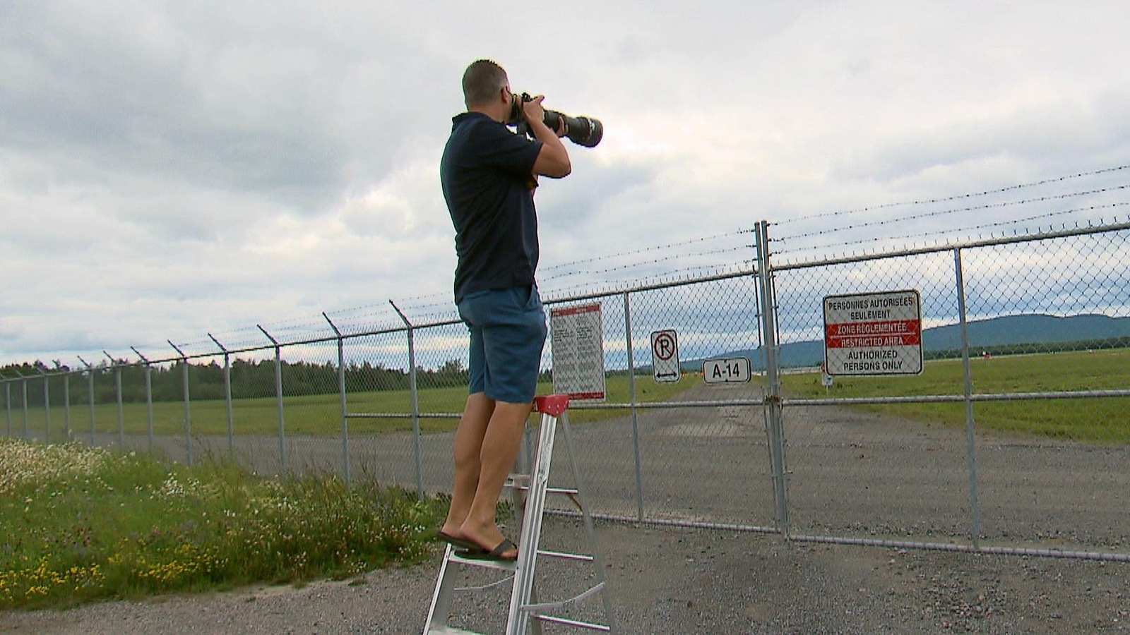 Un photographe juché sur une échelle Un photographe juché sur une échelle