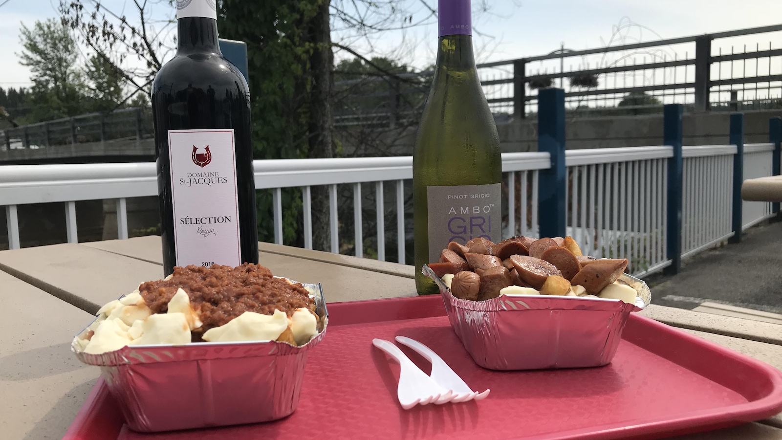 Deux bouteilles derrière deux plats de poutine Deux bouteilles derrière deux plats de poutine